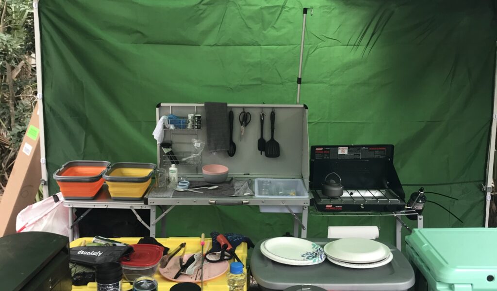 An organized outdoor camping kitchen setup featuring a camping stove.