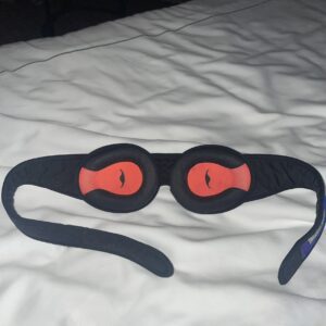 The Manta sleep mask on a bed. Showing the adjustable eye cups of the manta eye mask,