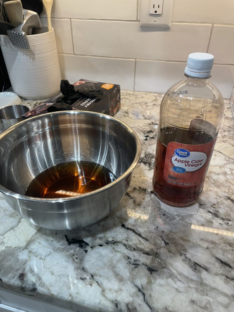 Demonstrating the making of vinegar sauce, an essential component of the pulled pork Traeger recipe.