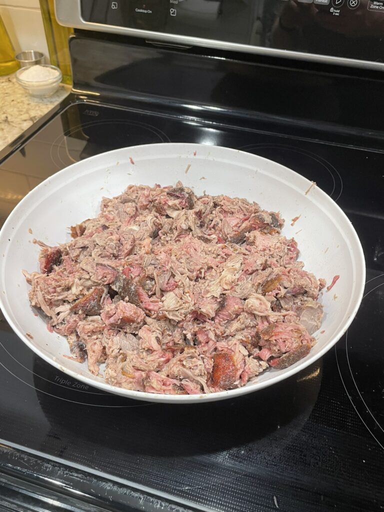 A bowl of pulled pork cooked on a Traeger grill, ready for serving.