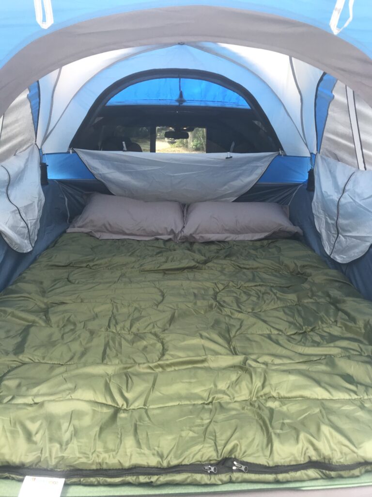 Inside view of a truck bed tent, showcasing a sleeping bag and mattress, ready for a comfortable truck camping night experience.