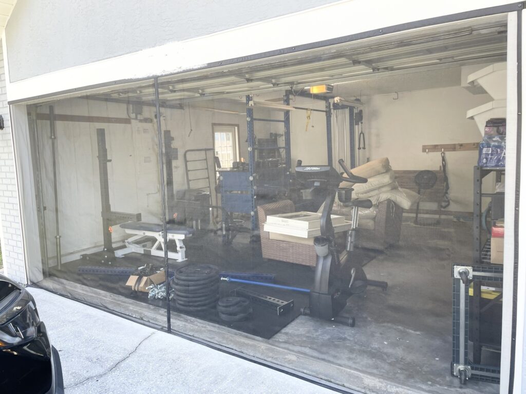 An exterior view of a house, focusing on the garage with a screen door for a garage.