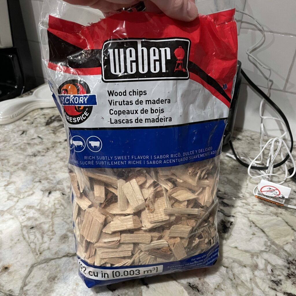 A close-up view of Weber Hickory Wood Chips, ideal for adding traditional, robust smoky flavor to your reverse sear ribeye steak.