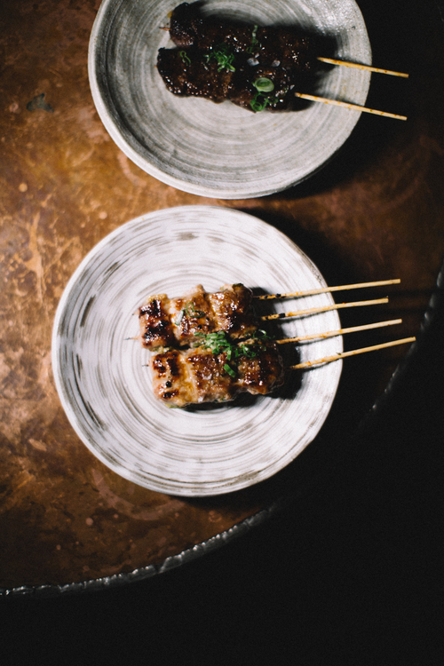 Sizzling skewers of meat being served at Double Knot, a top-rated Japanese restaurant Philadelphia boasts, exemplifying the mastery of Robatayaki cooking.