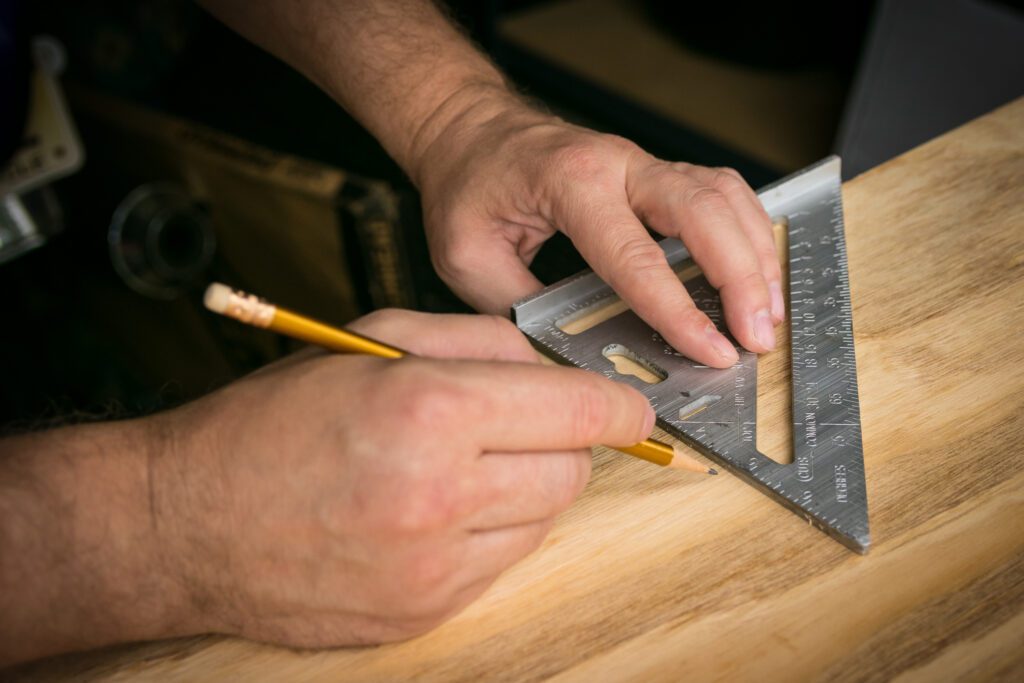 Man measuring wood for an accurate cut with a smart square tool.