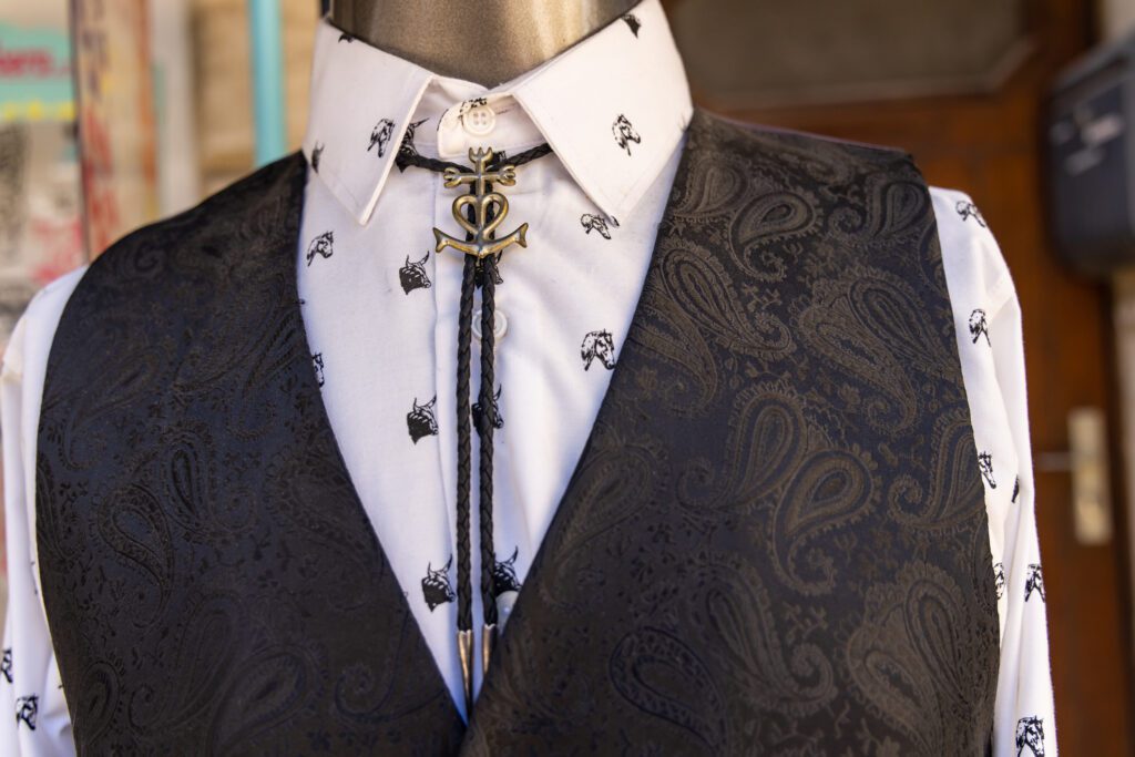 A mannequin wearing formal clothing paired with a bolo tie, demonstrating how to wear a bolo tie for a bolo tie wedding.