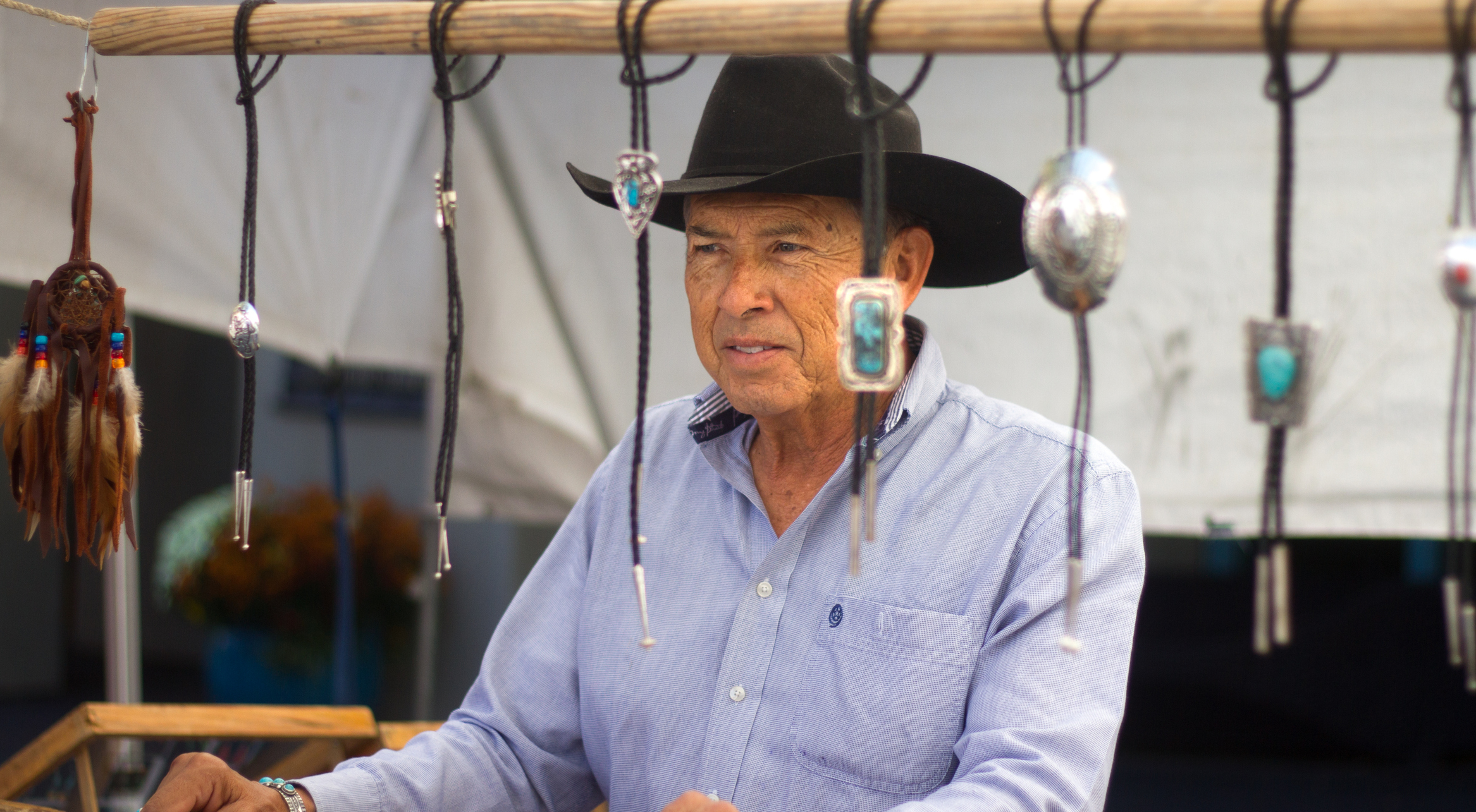 A man displaying multiple bolo ties, illustrating the versatility of the accessory.