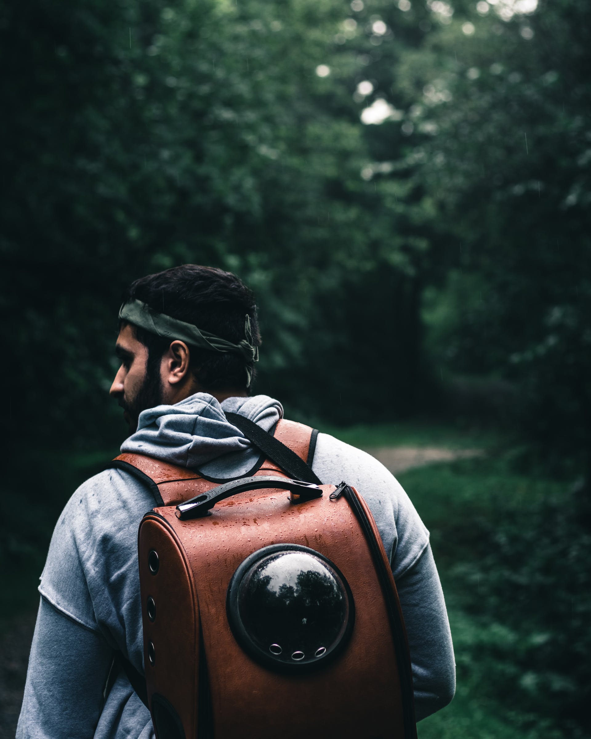 Man in forest showcasing the durability of the best travel backpack for men.