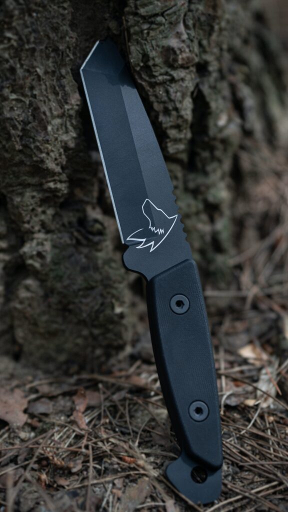 Close-up of a survival knife's fixed blade, showcasing the sharp edge and its sturdy material.