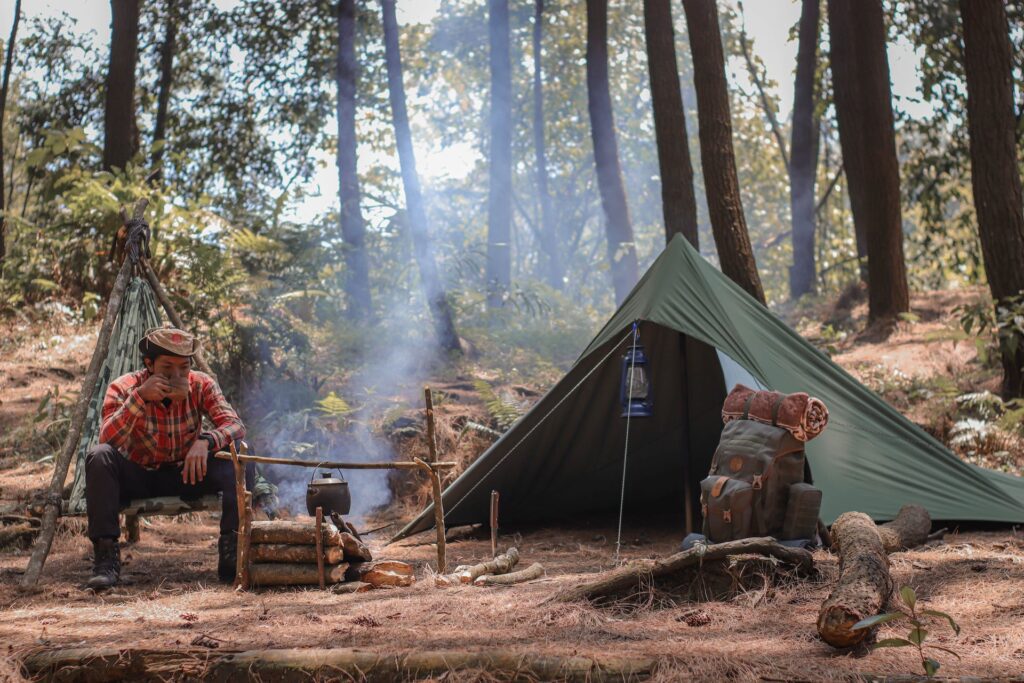 A survival knife being used in an outdoor setting, emphasizing its versatility in tasks like building a shelter.