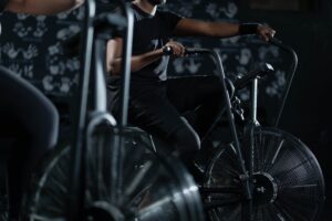 Man demonstrating proper use of an Assault Bike, providing an effective cardio workout, in comparison to a recumbent bike.