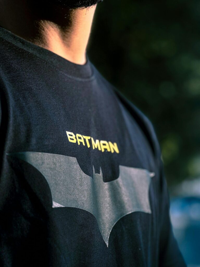 A man wearing a shirt with the Batman symbol on it.