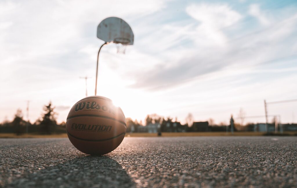 Basketball and hoop symbolizing Shaq O'Neal's towering height in the game. "How tall is The Shaq?" becomes evident when compared to a standard basketball hoop.