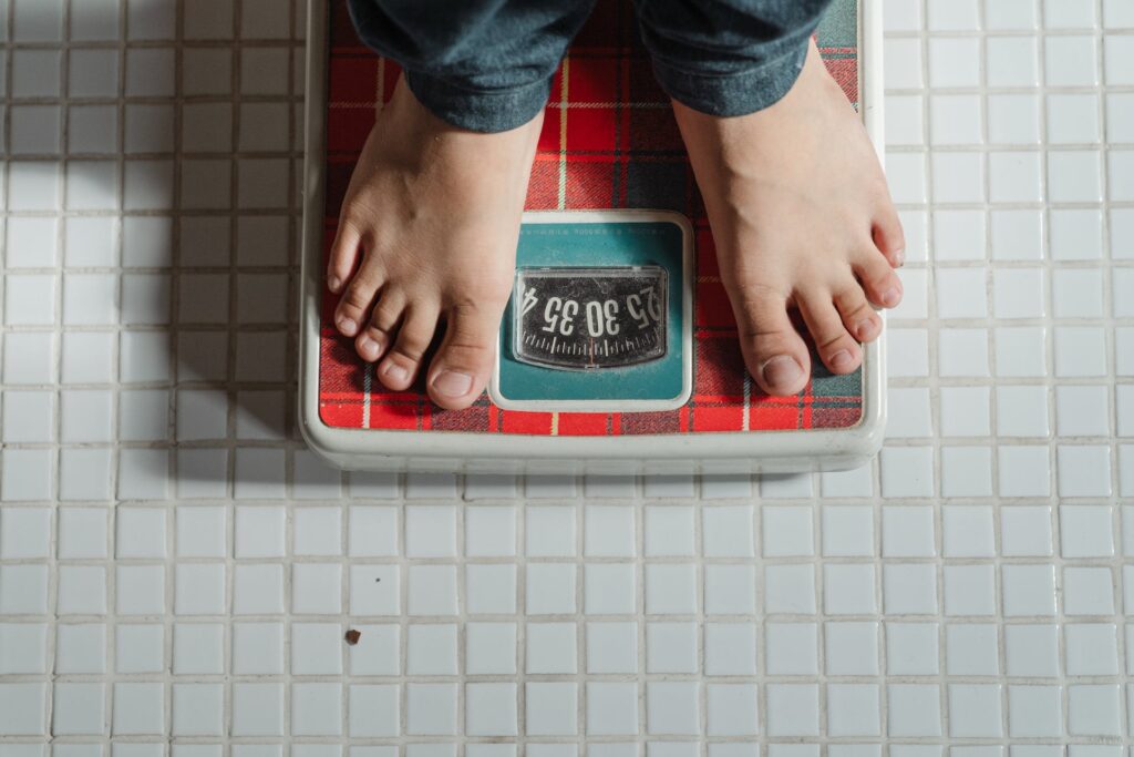 A man standing on a scale, symbolizing weight management benefits of incorporating Tuno, the sustainable seafood alternative, into daily diet.