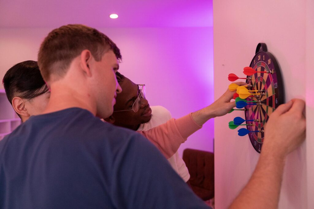 A player removing a dart from a soft tip dart board after a successful throw.