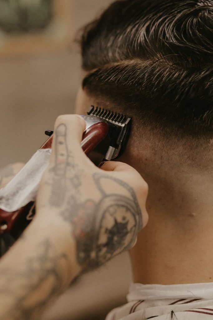 Mid-action shot of a barber giving a mid fade haircut, a unique blend between the classic mid taper and modern fade styles.