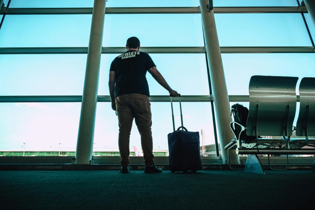 Man gazing out of an airport lounge window, enjoying the same tranquility as in Centurion lounge Charlotte