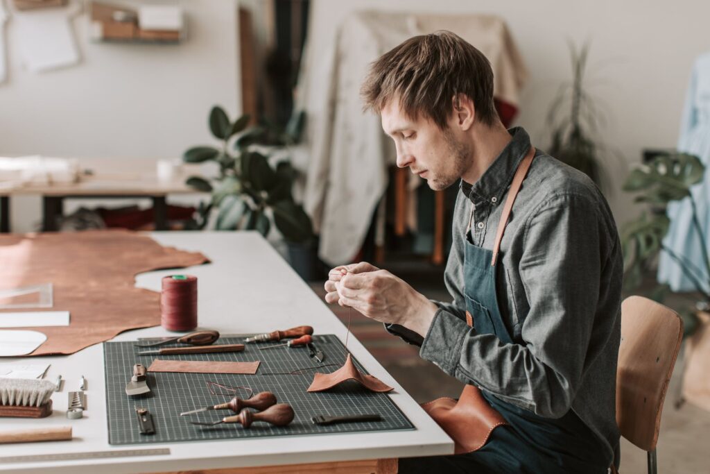 A man engaging in DIY fabric repair, sewing a hole in his clothing, applying techniques learned from a guide on how to sew a hole.