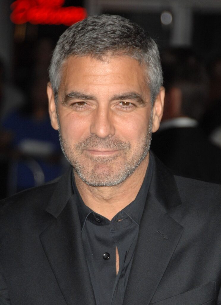 George Clooney sporting a short stubble, one of the popular short beard styles for men.